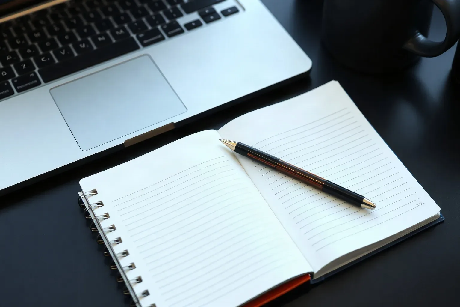 A spiral notebook lying open beside a keyboard